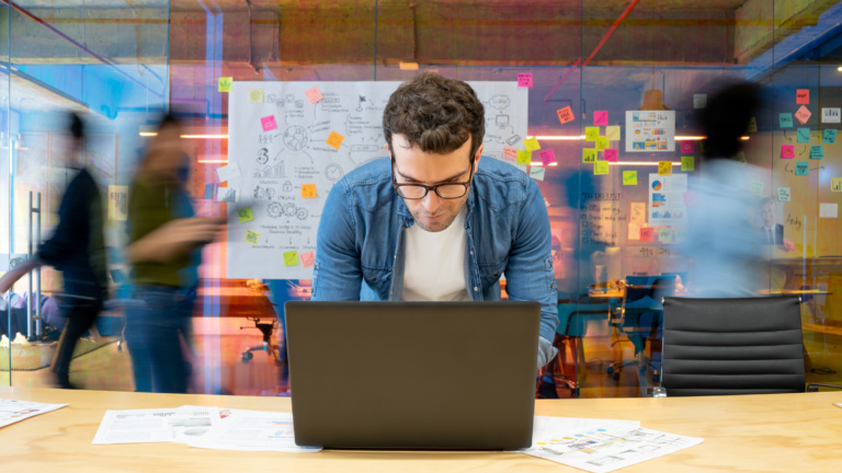 tech worker leaning into laptop
