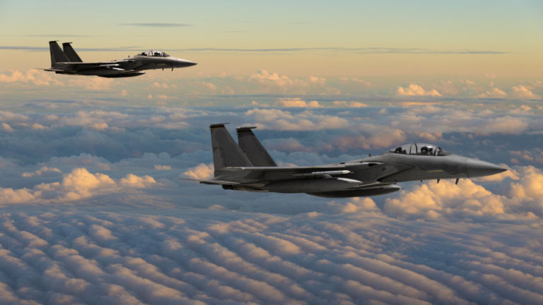 F-15 Eagle fighter jets flying above clouds