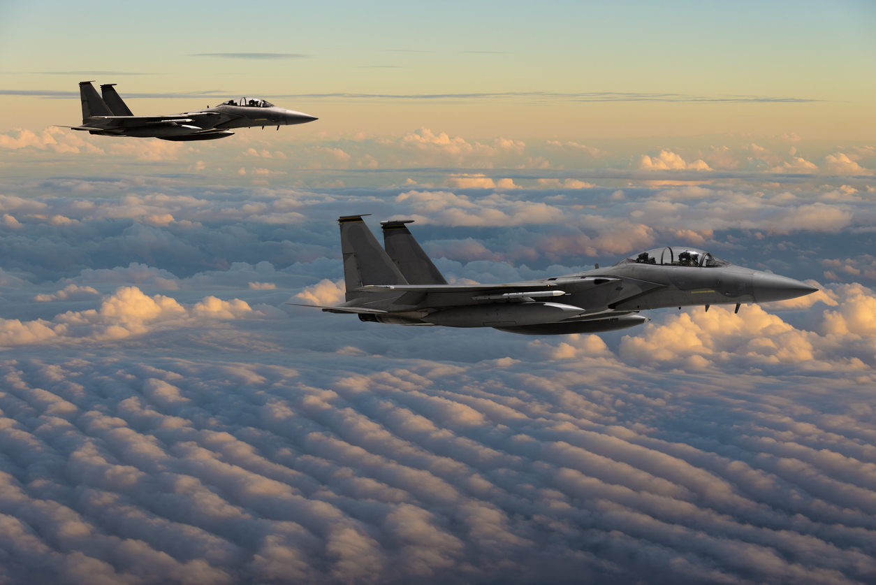 F-15 Eagle fighter jets flying above clouds